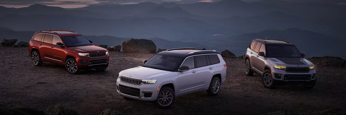 Three Jeep Grand Cherokee models parked off-road